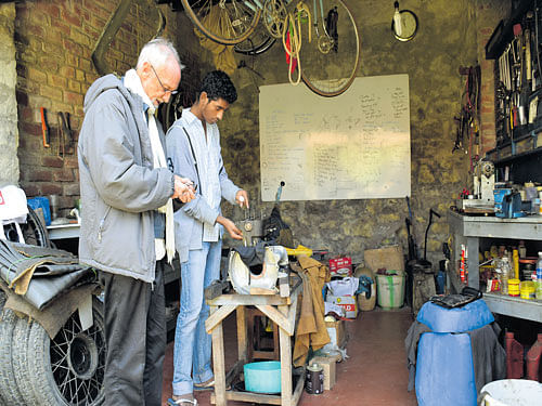 Brian Jenkins with a student in a garage in Sholai school in Tamil Nadu. Anitha Pailoor