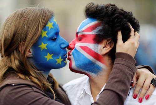 Two activists with the EU flag and Union Jack painted on their faces kiss each other in front of Brandenburg Gate to protest against the British exit from the European Union, in Berlin, Germany, June 19, 2016. REUTERS