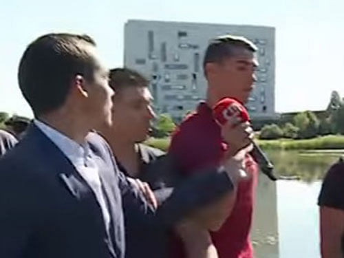 Video of the incident shows the reporter asking: 'Ronaldo, ready for the game today?' But without a word or glance at the journalist, Ronaldo took his microphone and threw it in the lake, then carried on with the team stroll. Screen grab.