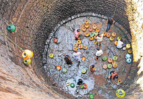 Parched lives: People risk their lives to collect a pot of water from a well where the district administration pours water from tankers. Almost 70% of Indians live in rural areas, but the government doesn't appear to view them as essential to India's march to growth. DH photo