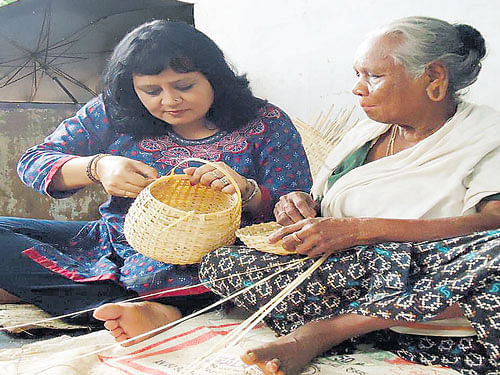 Neera Sarmah weaves a basket with an artisan. photo by sinha