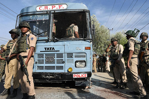 Security forces inspect a CRPF bus which was attacked by militants on Srinagar-Jammu National Highway on the  outskirts of Srinagar on Saturday.  PTI