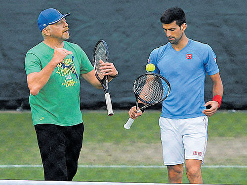plotting a hat-trick: Coach Boris Becker (left) offers tips to Novak Djokovic during a training session on&#8200;Sunday. AP/ pti
