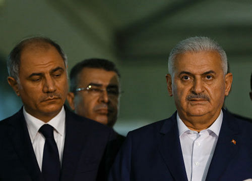 Turkey's Prime Minister Binali Yildirim speaks to the press next to the Interior Minister Efkan Ala at the Ataturk airport in Istanbul. Reuters photo