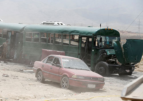 Afghan security forces inspect the damage on buses hit by suicide bombers at the site of an attack on the western outskirts of Kabul. Reuters Photo