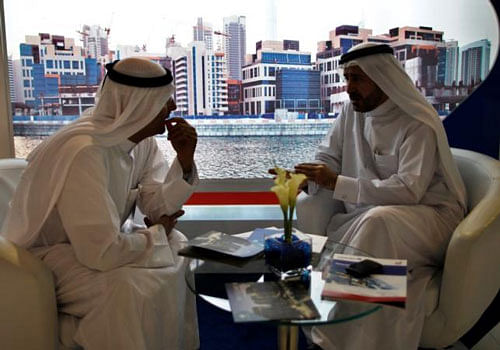 Businessmen speak to each other during the Cityscape real estate exhibition in Dubai October 2, 2012. REUTERS file photo
