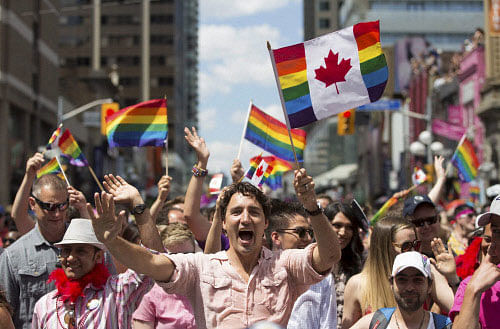 Prime Minister Justin Trudeau waves a flag as he takes part in the annual Pride Parade in Toronto on Sunday, July 3, 2016. AP/PT