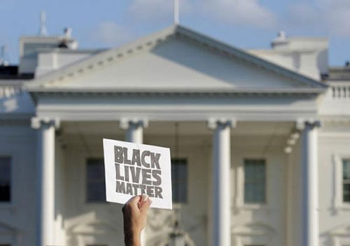 A demonstrator with Black Lives Matter holds up a sign during a protest in front of the White House in Washington, U.S., July 8, 2016. Reuters