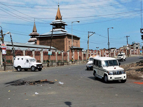 Security personnel patrol a deserted street during a curfew imposed by the authorities to maintain law and order following the killing of most wanted militant commander Burhan Wani, in Srinagar on Sunday. PTI Photo