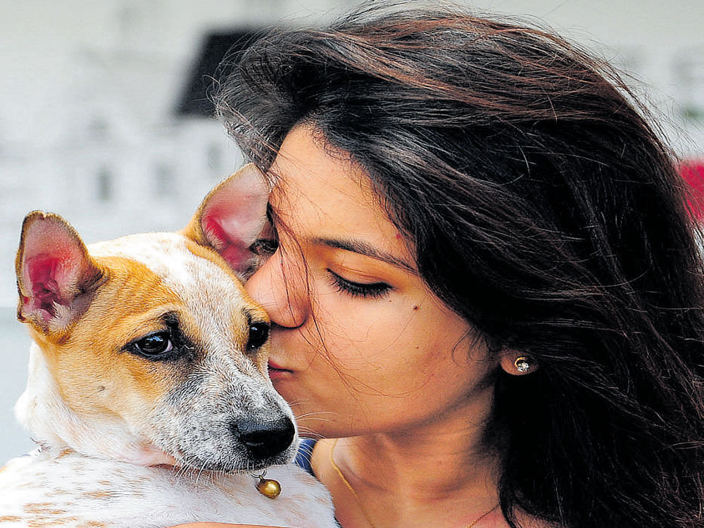 A pet lover poses with her dog at the second edition of 'Bengaluru opts to adopt' event in the city on Sunday. DH photo
