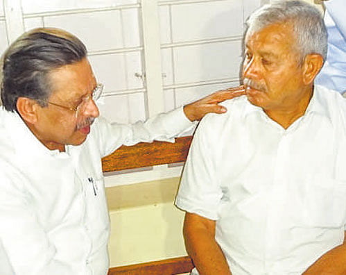 District incharge minister Seetharam consoles Ganapathi's father Kushalappa at his house. dh photo