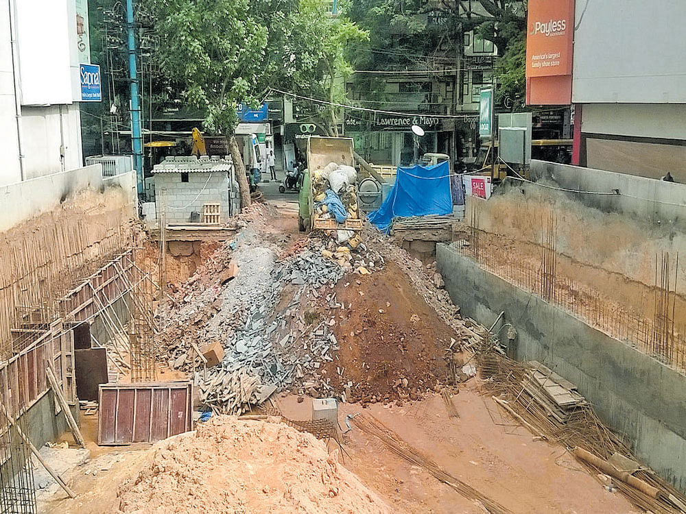 Loads of construction debris and soil are being dumped into the foundation pit at a construction site where three workers were killed in a mudslide in Koramangala last week. DH photo