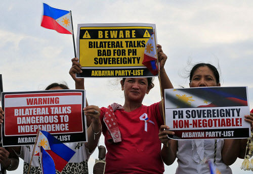 Protesters display placards during a rally by different activist groups over the South China Sea disputes, along a bay in metro Manila. Reuters photo