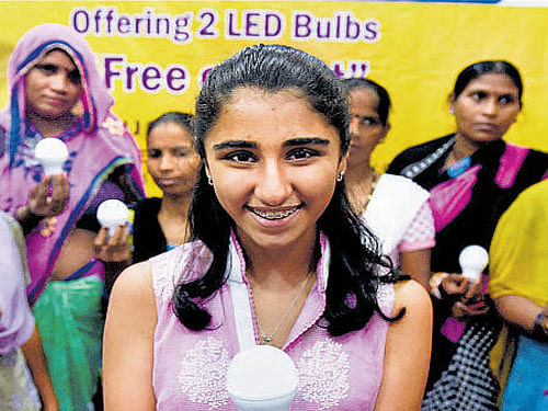 US-born Meera Vashisht distributes LED bulbs to  underprivileged people in New Delhi on Wednesday. PTI