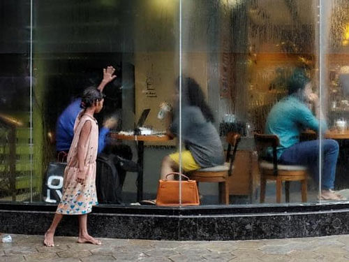 A girl asks for alms outside a coffee shop in Mumbai. Reuters file photo