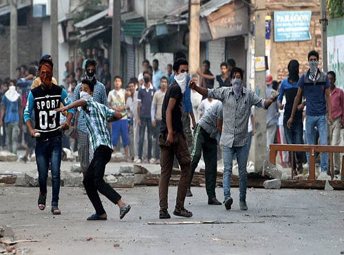 Youths throwing stones at security forces during a clash in Srinagar. PTI