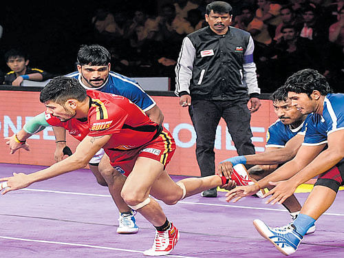 tough battle Bengaluru Bulls' Rohith Kumar (left) tries to escape from being caught by the Dabang Delhi players  during their PKL clash on Friday. DH Photo/ Srikanta Sharma R