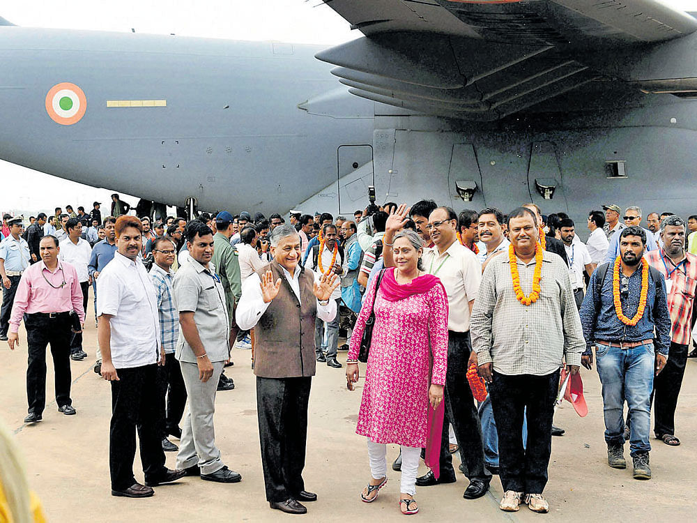 Minister of State for External Affairs V K Singh with Indians evacuated from South Sudan on their arrival at Palam Air Force Station in New Delhi, on Friday. PTI