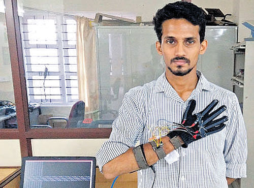 Student Deepak Ramuses the Mudra glove to gesture the word please