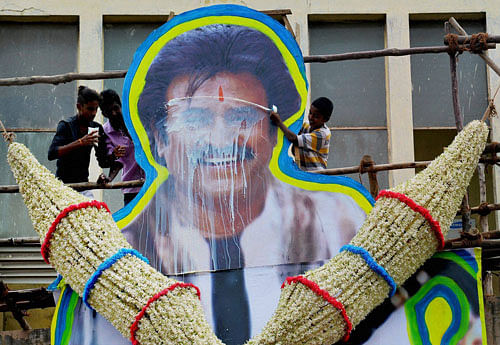 A fan pours milk on the poster of Super star Rajnikanth at the release of his new film 'Kabali' in Bengaluru on Friday. PTI Photo