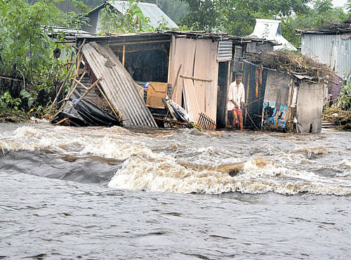 Swollen Sahu river flows past a submerged house at Sahudangi village, on the outskirts of Siliguri in West Bengal on Friday. PTI
