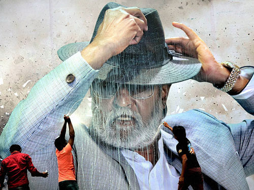 Fans pour milk on a giant poster of actor Rajinikanth to celebrate the screening of 'Kabali' in Chennai on Friday. PTI photo