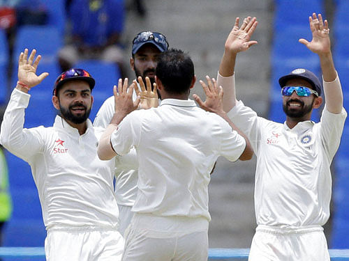 Mohammed Shami, back to camera, celebrates with teammates after taking the wicket of West Indies' Darren Bravo during day three of their first cricket Test match at the Sir Vivian Richards Stadium in North Sound, Antigua. AP/PTI