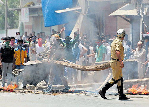 STILL ON THE BOIL: Police remove barricades put up by protesters in Srinagar on Saturday. PTI
