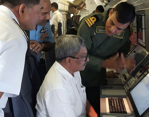 Defence Minister Manohar Parrikar being briefed on the search operations onboard the P 8i aircraft. PTI