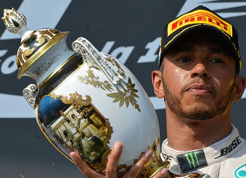 British Formula One driver Lewis Hamilton celebrates with the trophy on the podium after winning the Formula One Hungarian Grand in Mogyorod, north-east of Budapest, Hungary, Sunday, July 24, 2016. AP/PTI