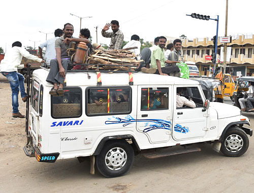 Commuters travel on the roof of a multi-utility vehicle in  Kalaburagi. DH PHOTO