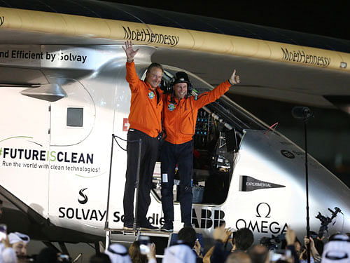 Pilots Andre Borschberg and Bertrand Piccard celebrate their arrival on Solar Impulse 2, a solar powered plane, at an airport in Abu Dhabi, UAE. Reuters