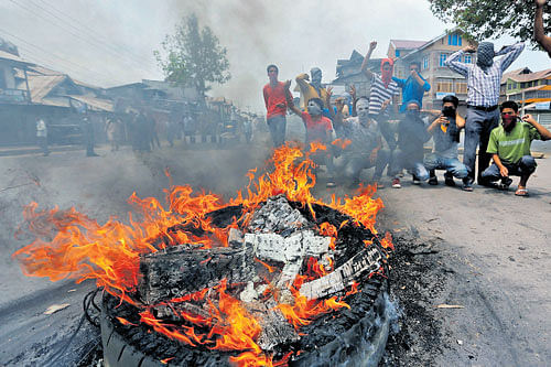 'Stop the killings': Demonstrators shout slogans next to a burning tyre during a protest in Srinagar against the recent killings in Kashmir, on Tuesday. REUTERS
