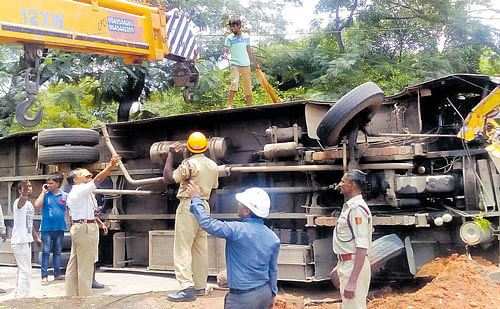 reckless: Fire personnel use a crane to lift the bus that overturned after it hit a tree near Agara on Wednesday.  (Inset) A view of the damaged bus. DH Photo