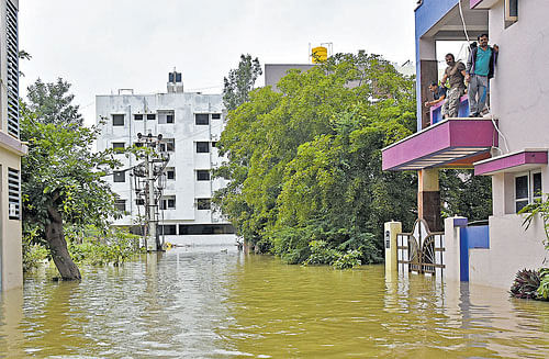 Residents look on as a street in Kodichikkanahalli is flooded on Friday. DH&#8200;photo/ M&#8200;S&#8200;Manjunath