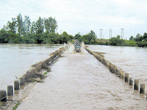 A bridge constructed across the Kagina river near Dandoti village of Chittapura taluk in Kalaburagi district was submerged, affecting traffic for more than 10 hours. DH Photo.