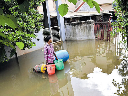 A resident of Ashwath Narayana Layout in JP Nagar moves out of his submerged house with his belongings on Sunday. DH PHOTO/Kishor Kumar Bolar