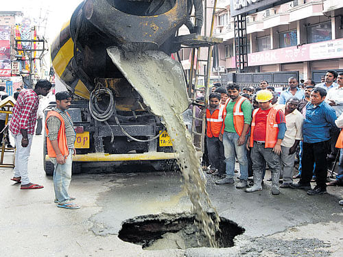 Concrete is being filled into the huge sinkhole that opened up on the busy KG&#8200;Road on Tuesday. DH Photo