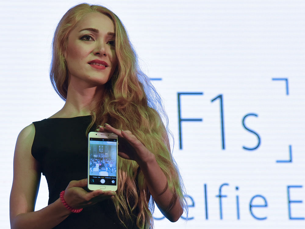 A model displays the newly launched Oppo phone in Bengaluru. DH photo