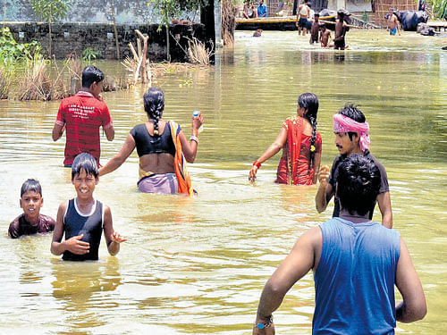 People wade through floodwaters in the east Champaran district of Bihar on Wednesday. PTI