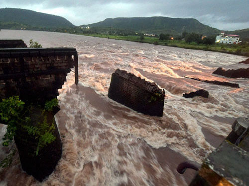 The remaining portion of washed away Mahad-Poladpur bridge by the flood waters of Savitri river on the Mumbai-Goa highway in Raigad district on Wednesday. PTI Photo