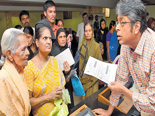 Commissioner of Food and Civil Supplies Department Harsh Gupta verifies the APL and BPL ration cards of citizens at a BangaloreOne centre for issue of food grain coupons in  Bengaluru on Saturday. DH Photo