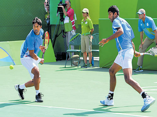 early exit India's Leander Paes (left) prepares to return while partner Rohan Bopanna looks on during their opening round clash on Saturday. DH photo