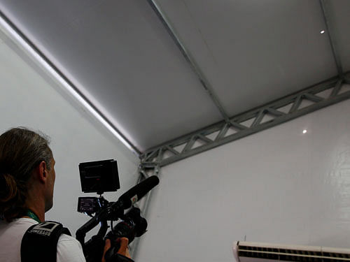 A television cameraman films two holes in the tent that serves as a media center at the Deodoro equestrian center in Rio de Janeiro . Reuters