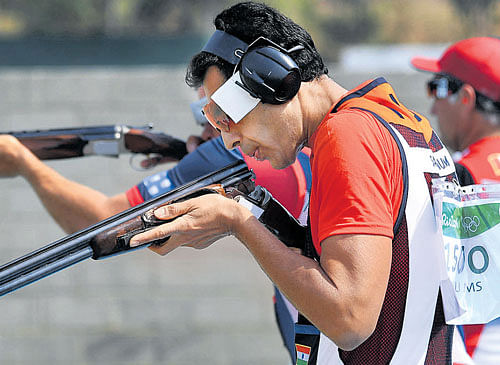 focused India's Manavjit Sandhu competes in the qualification round of the men's trap event at Rio de Janeiro on Sunday. DH photo