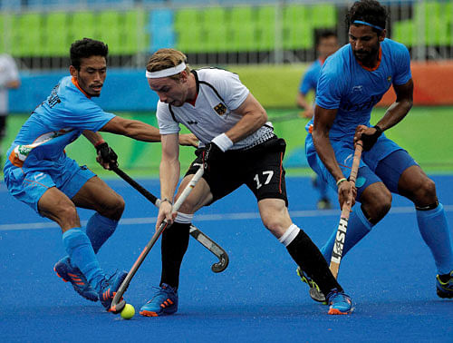 Germany's Christopher Rhur, center, fight for the ball against India's Kothajit Khadangbam, left, and India's Rupinder Pal Singh, right, during a men's field hockey match at 2016 Summer Olympics in Rio de Janeiro, Brazil, Monday, Aug. 8, 2016. AP/PTI