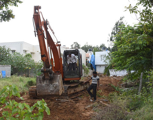 BBMP workers reconstruct the Rajakaluve and feeder  channel in Kasavanahalli, on Monday. DH Photo