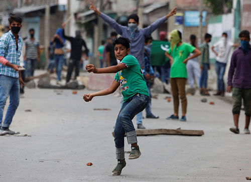 Still on the boil: Protesters throw stones at security forces in Batmaloo area of Srinagar on Tuesday. Reuters