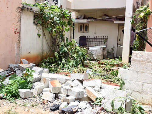 Late Lt Col Niranjan Kumar, who was killed in the operation at the Indian Air Force base in Pathankot, his house compound wall demolished during encroached Rajakaluve at Dodda Bommasandra in Bengaluru on Thursday. DH Photo.