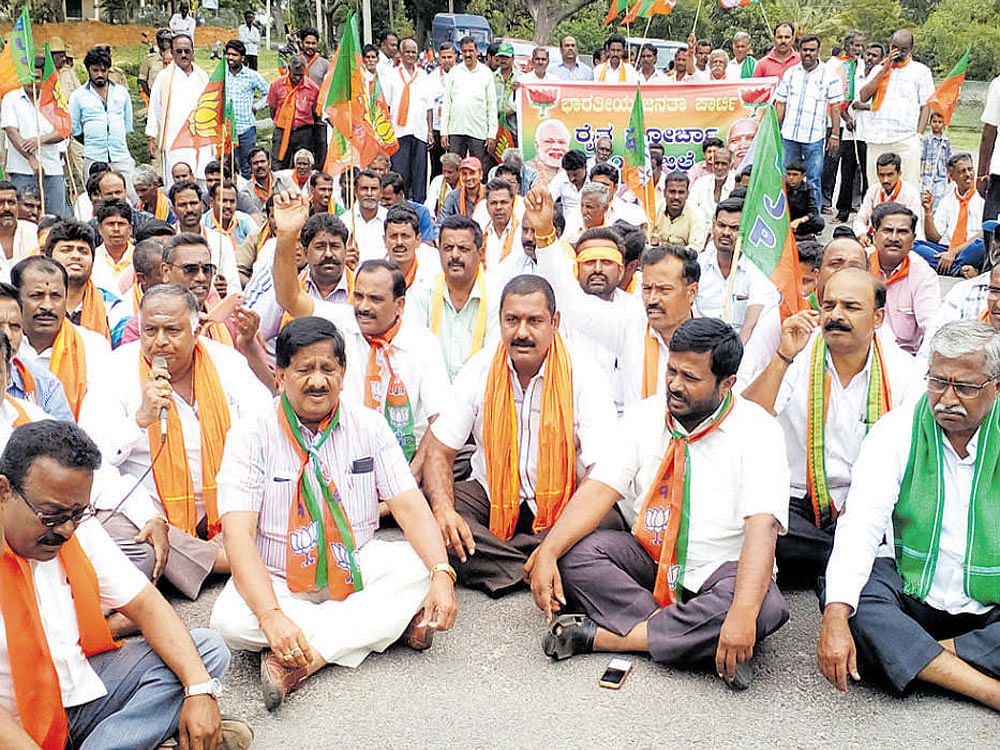 BJP workers stage a dharna in front of the main entrance of the KRS dam in Srirangapatna taluk of Mandya district on Saturday. DH photo